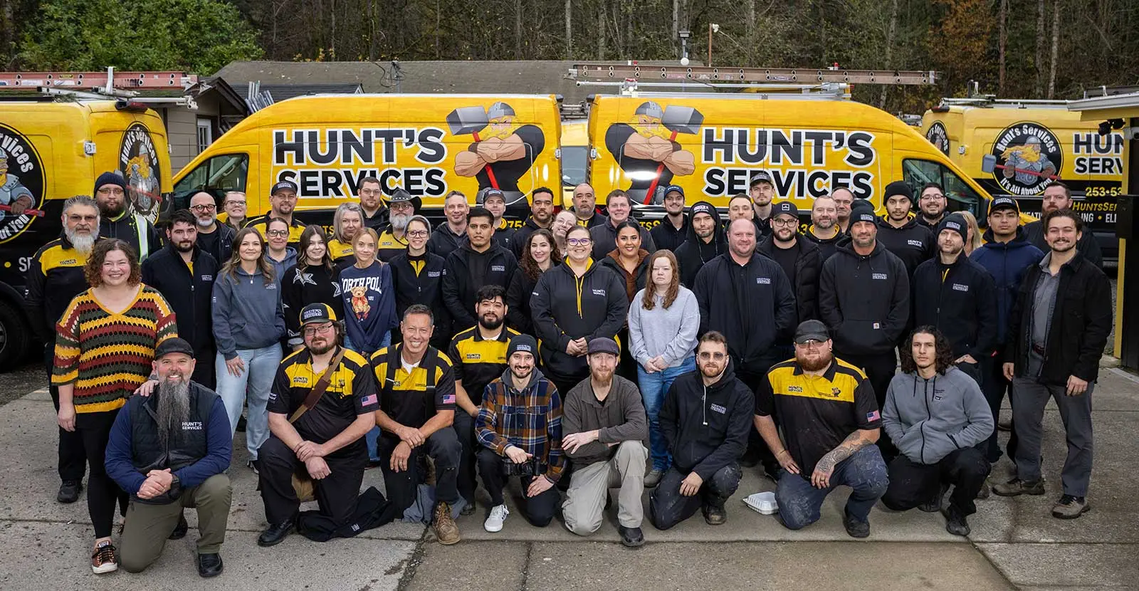 The Hunt’s Services team in front of the company’s yellow service vans